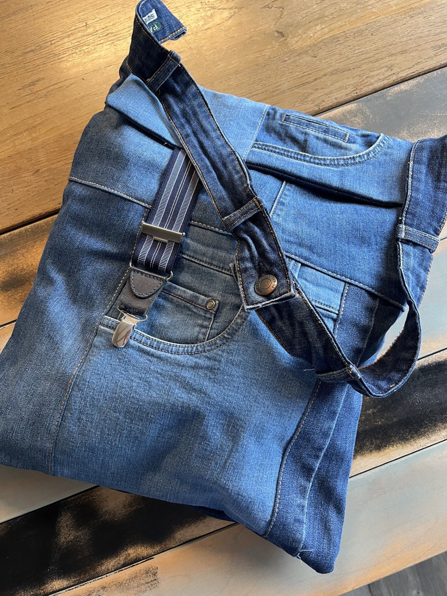 tas gemaakt van blauwe spijkerbroeken met specifieke details zoals zakken en stiksels en een sluiting van bretels