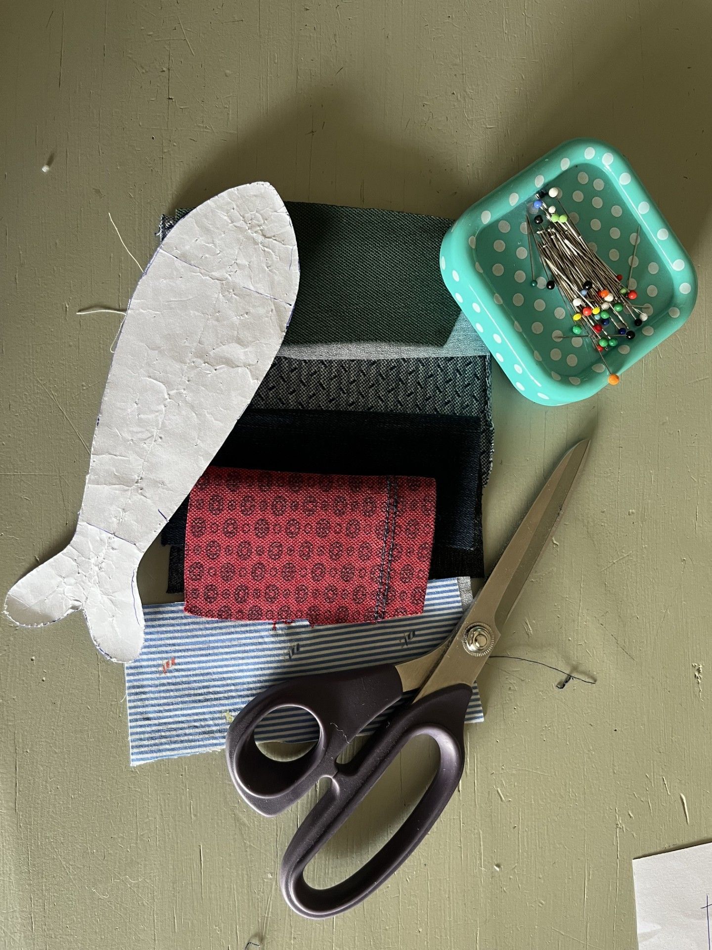 detailfoto van kleding dierbare en een patroontje van vis op de werktafel in atelier Biezonder
