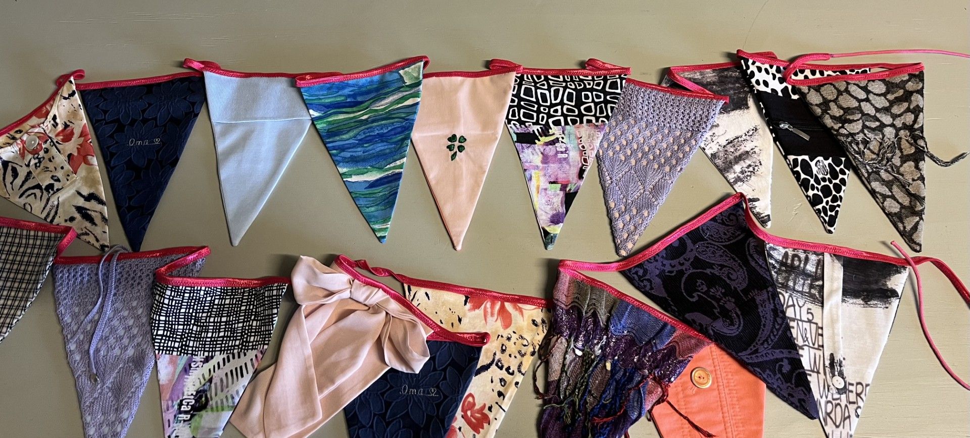 vlaggenlijn met veel mooie details afgewerkt met een roze lint en verpakt in een tasjevan kleding van een oma 