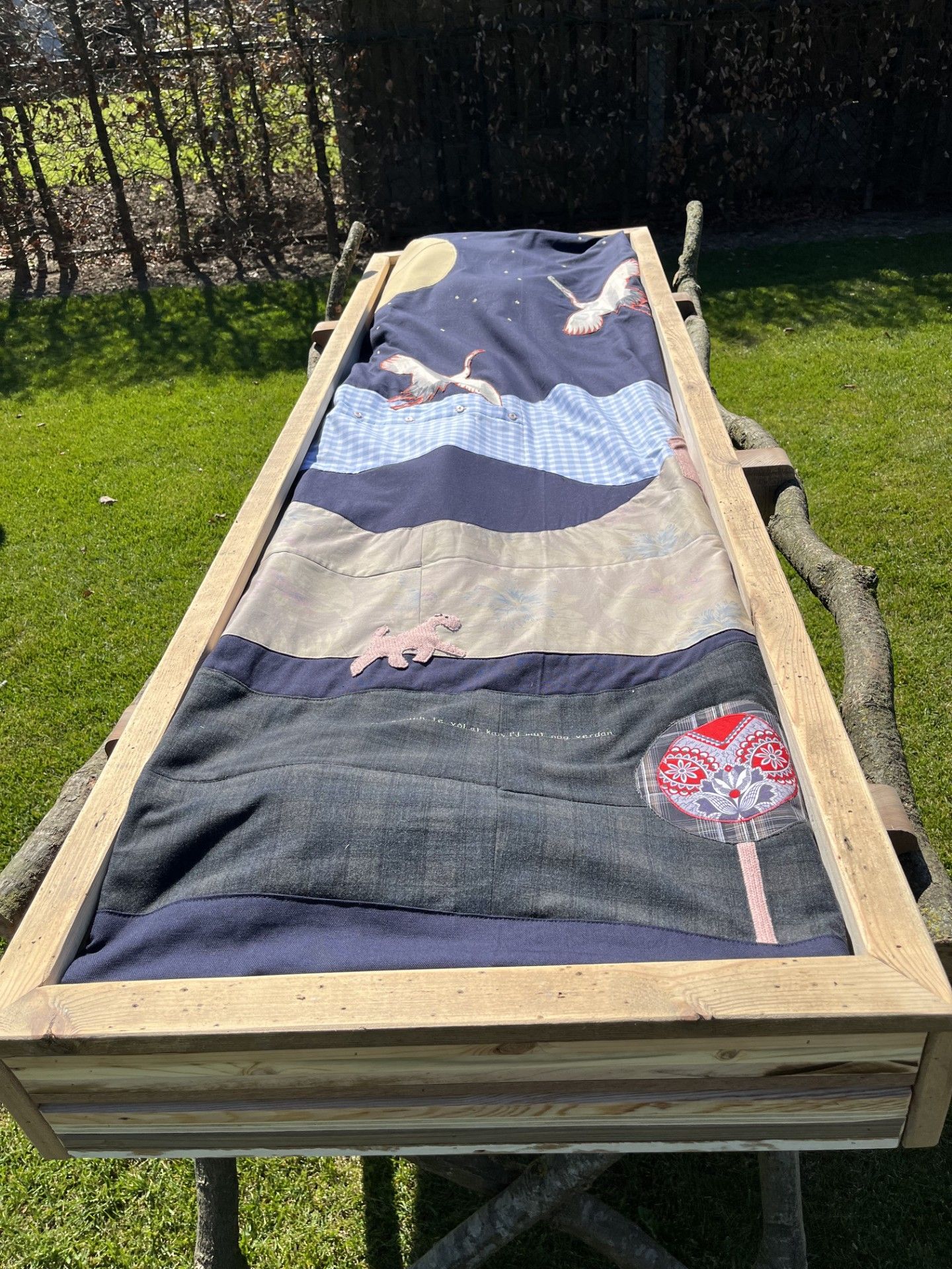Een wade gemaakt van kleding dierbare ligt op een baar van sloophout