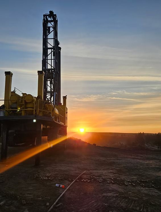 Sunset over an industrial drilling rig silhouetted against a clear sky