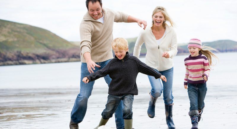 A family is running on the beach.