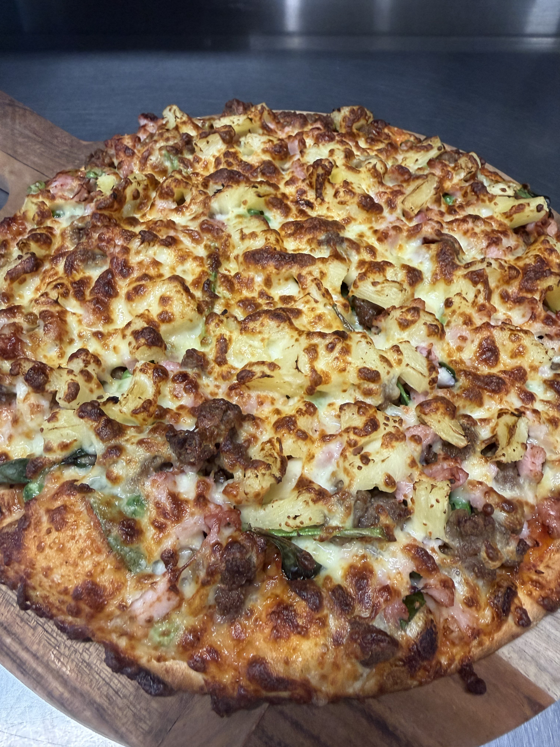 A Pizza With Shrimp, Peppers, Cheese And Tomatoes Is Sitting On A Table — Bel-Air Pizza In Port Macquarie, NSW