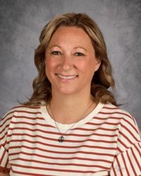 Smiling woman in a white and red striped shirt against a gray studio backdrop