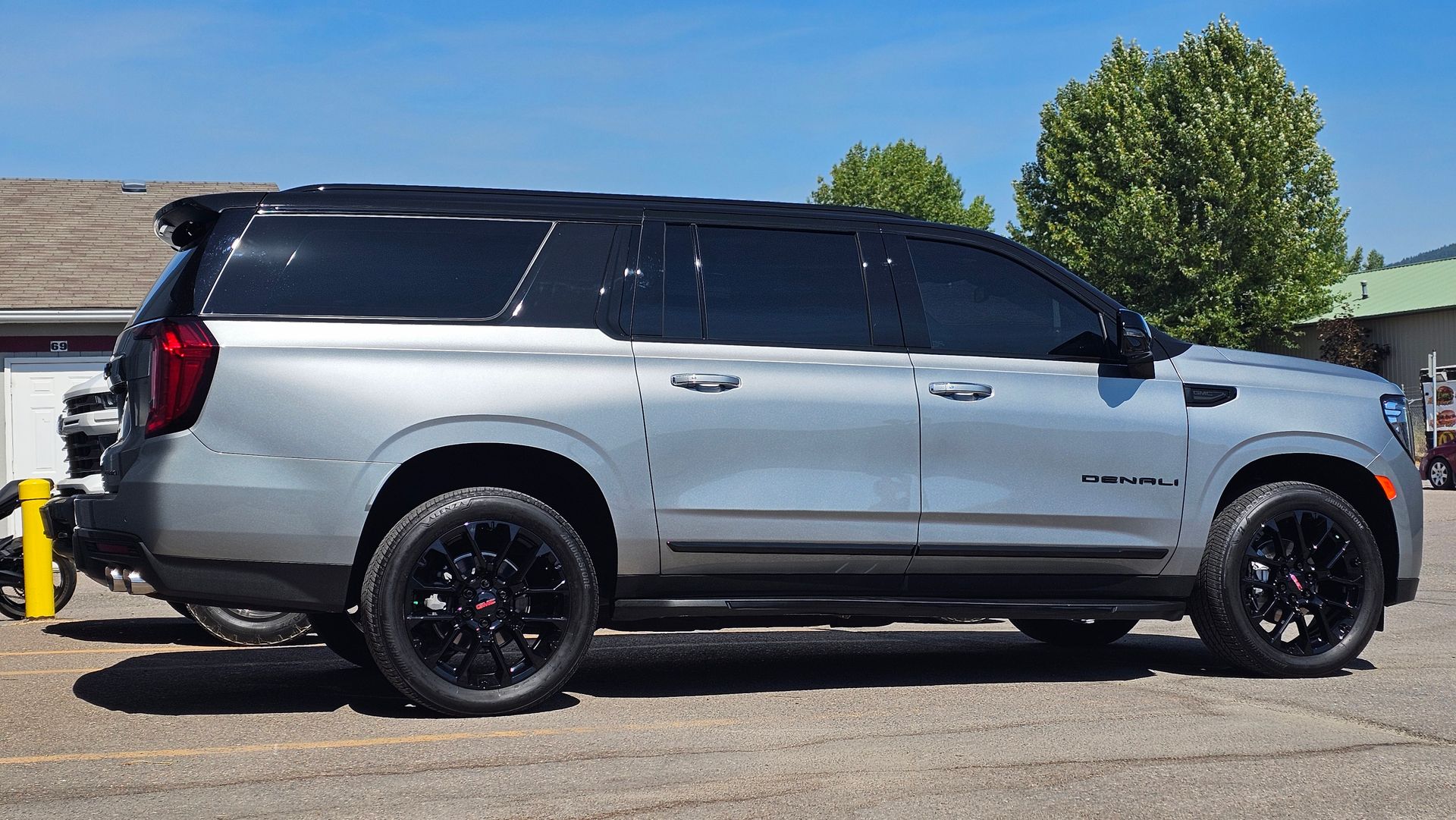 Silver SUV with black roof and wheels parked in a lot on a sunny day