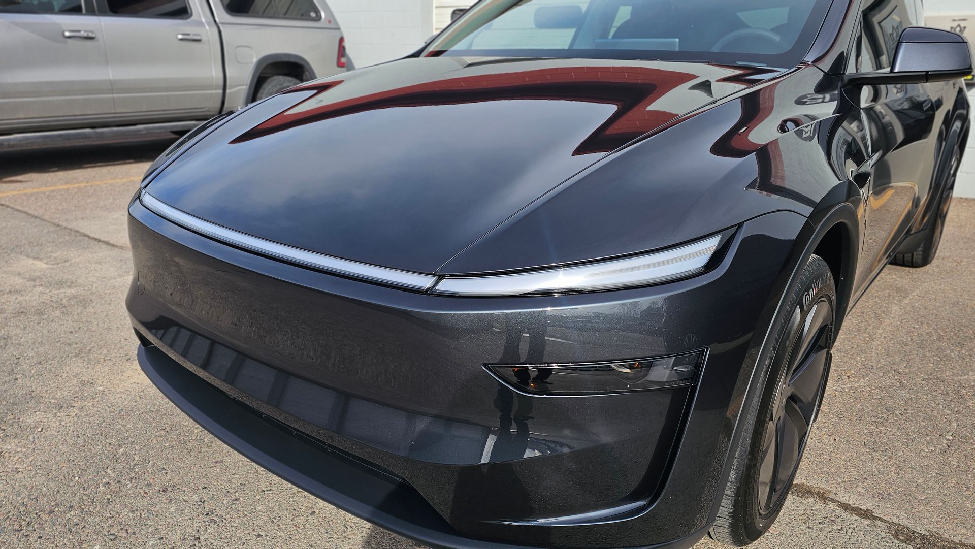 Front view of a dark blue Tesla parked outdoors in a lot