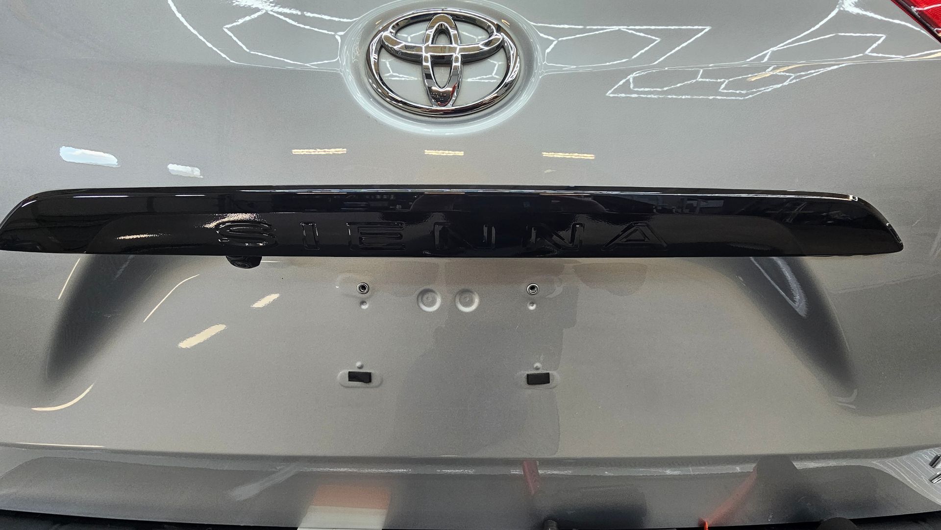 Close-up of a silver Toyota SUV rear hatch with black trim and badge visible