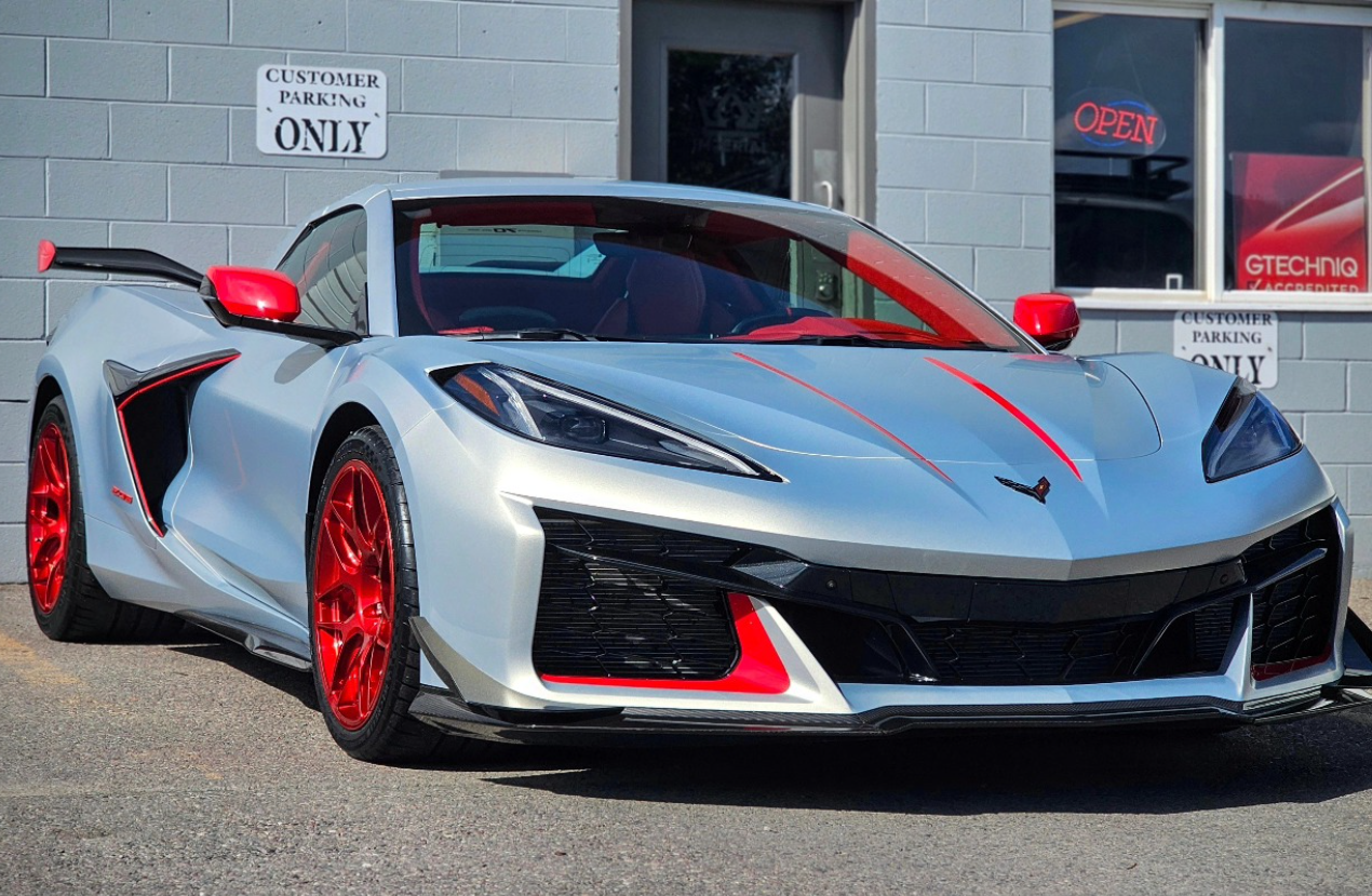 Silver sports car with red accents parked outside a building