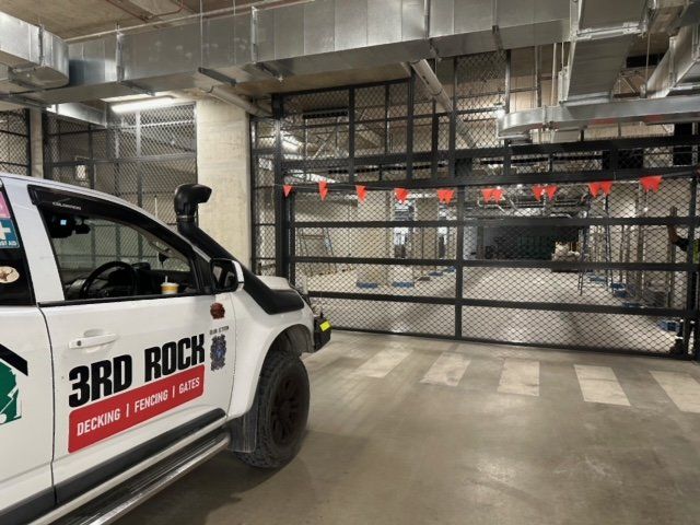 White 3rd Rock utility truck parked beside a gated industrial garage entrance