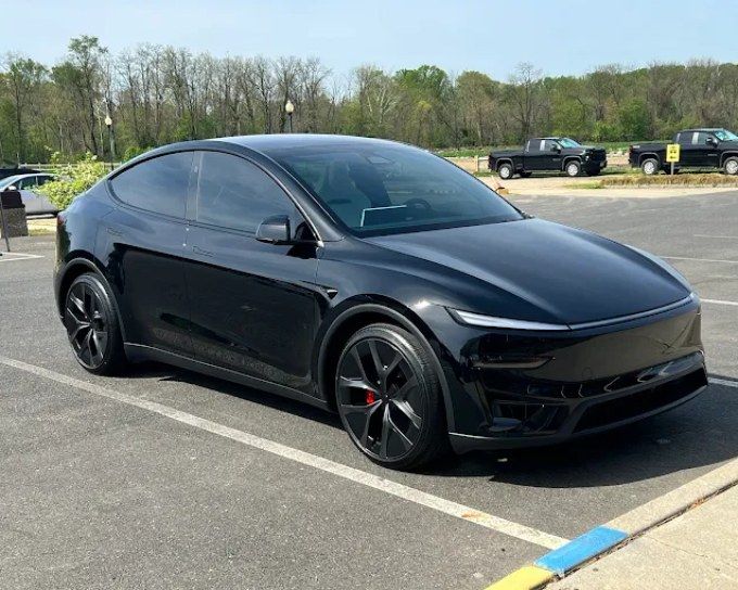 Black sports car featuring dark window tint and a polished exterior finish.
