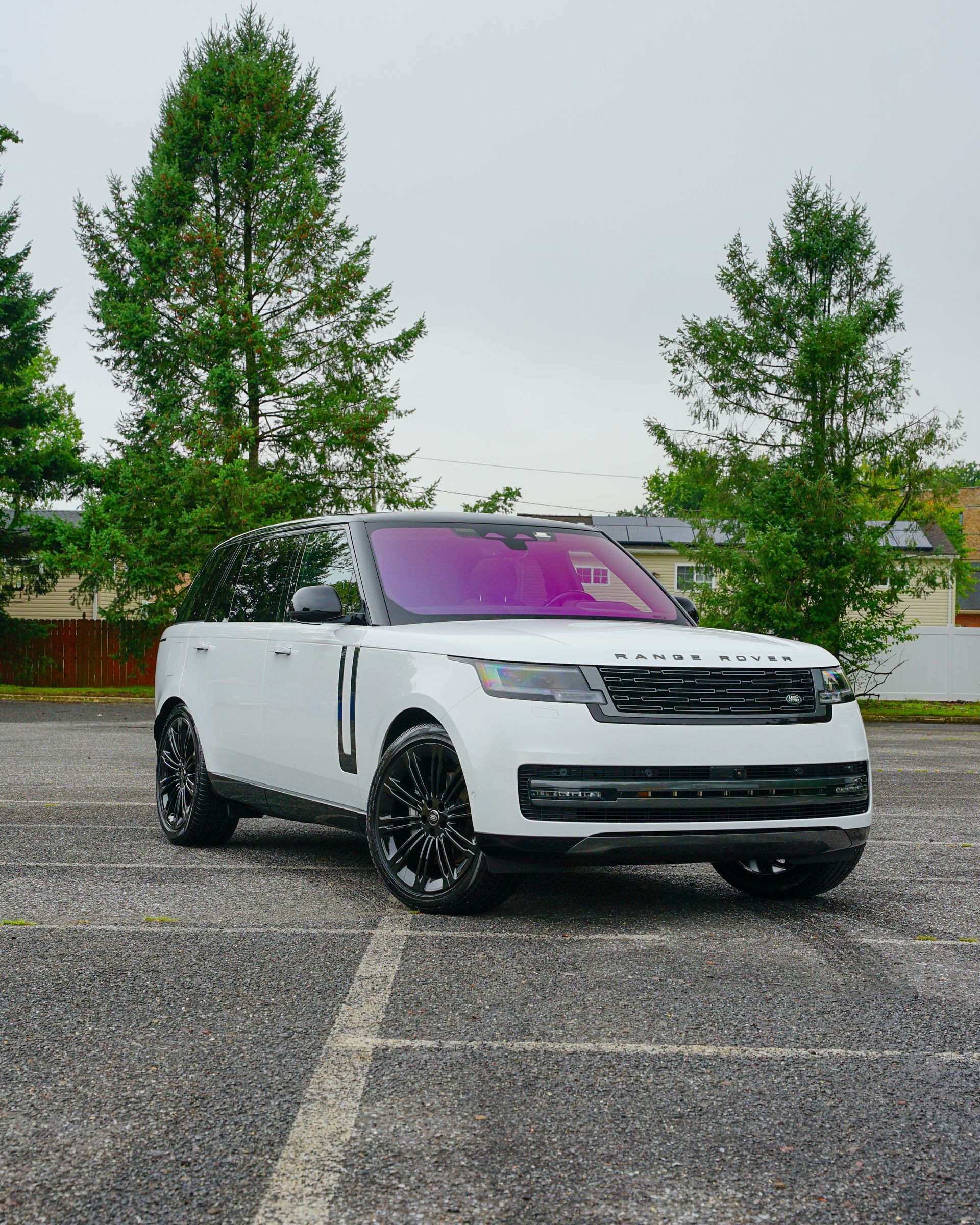 a white range rover is parked in a parking lot