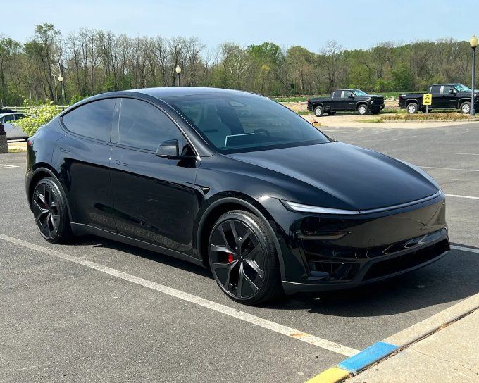 Black Tesla Model Y with darkened windows showing professional automotive window tinting