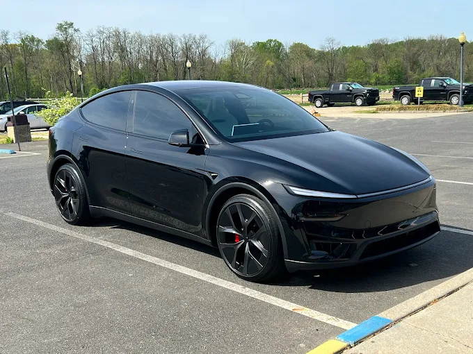 Black Tesla Model 3 with ceramic coating applied, showcasing sleek gloss finish and paint protection in parking lot