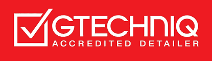 Logo with a checkmark in a box, “Gtechniq” and “Accredited Detailer” on a red background.