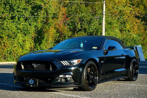 Black Ford Mustang GT with PPF paint protection film applied, highlighting deep gloss finish and front bumper protection