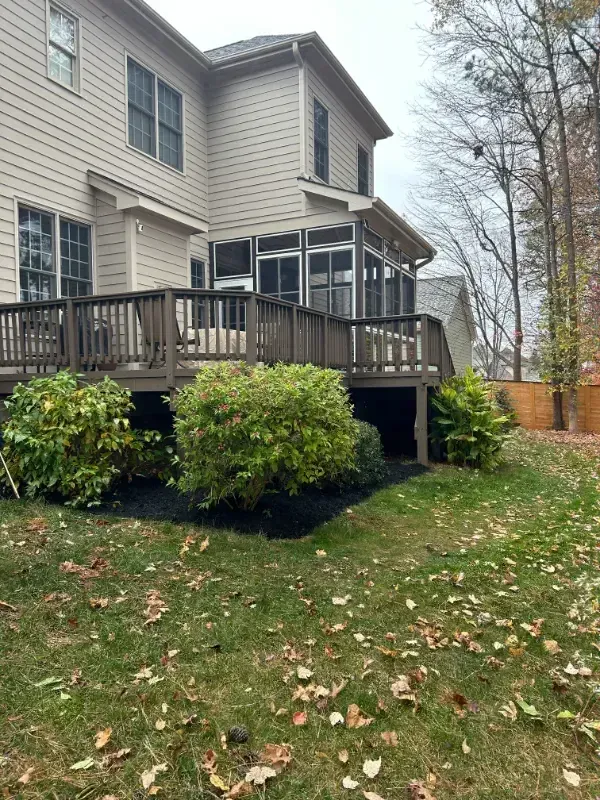 A large house with a screened in porch and a large deck.
