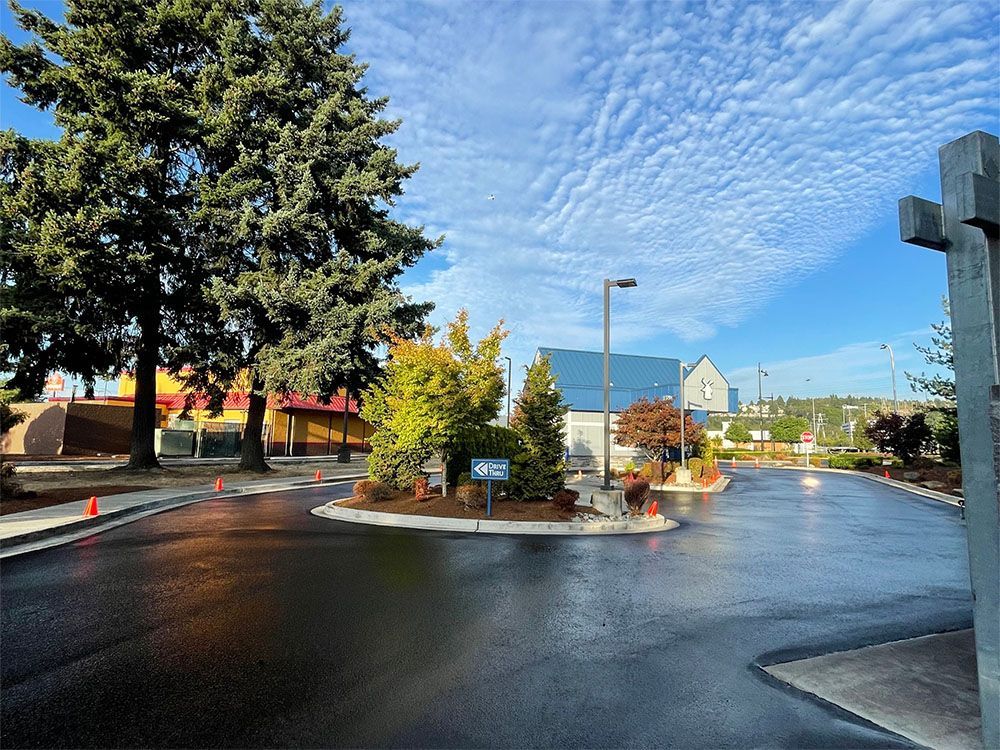 A parking lot with trees and a building in the background
