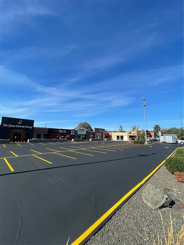 A parking lot with a few buildings in the background