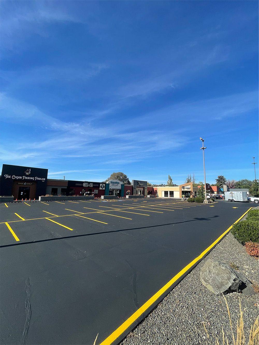 There is a playground in the middle of a parking lot.
