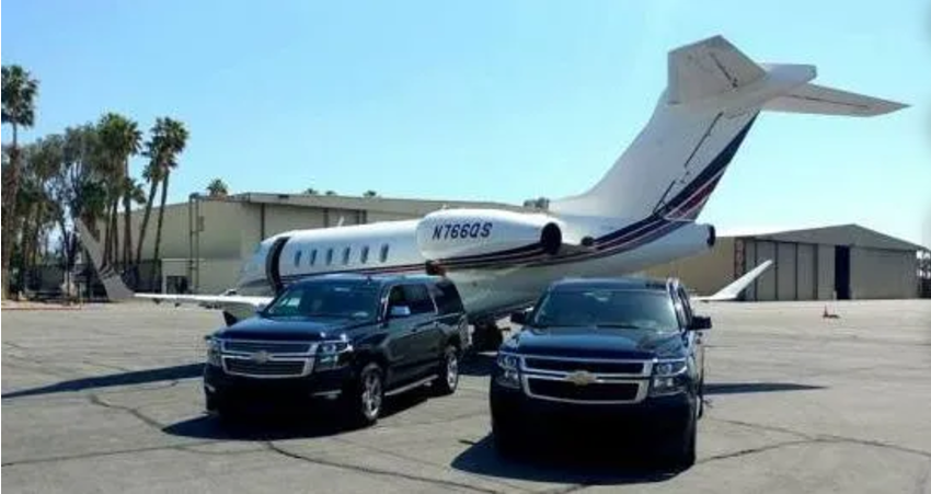 Two cars are parked in front of a plane that says n1805s