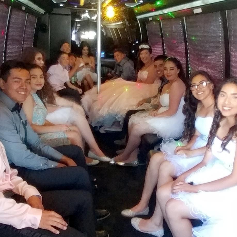 People inside a limousine. Several young people are dressed up, celebrating.