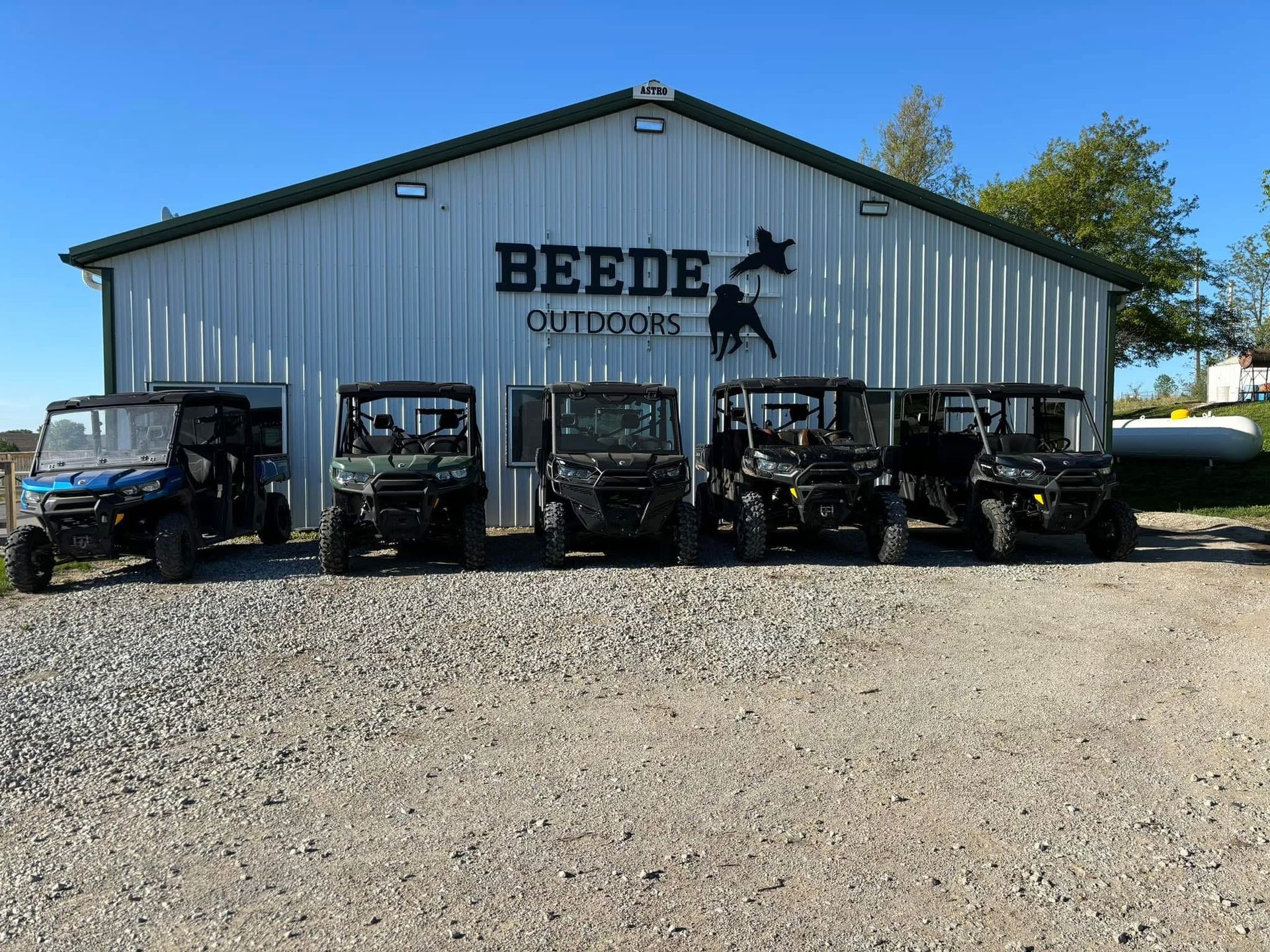 Five side-by-side UTVs parked in front of 