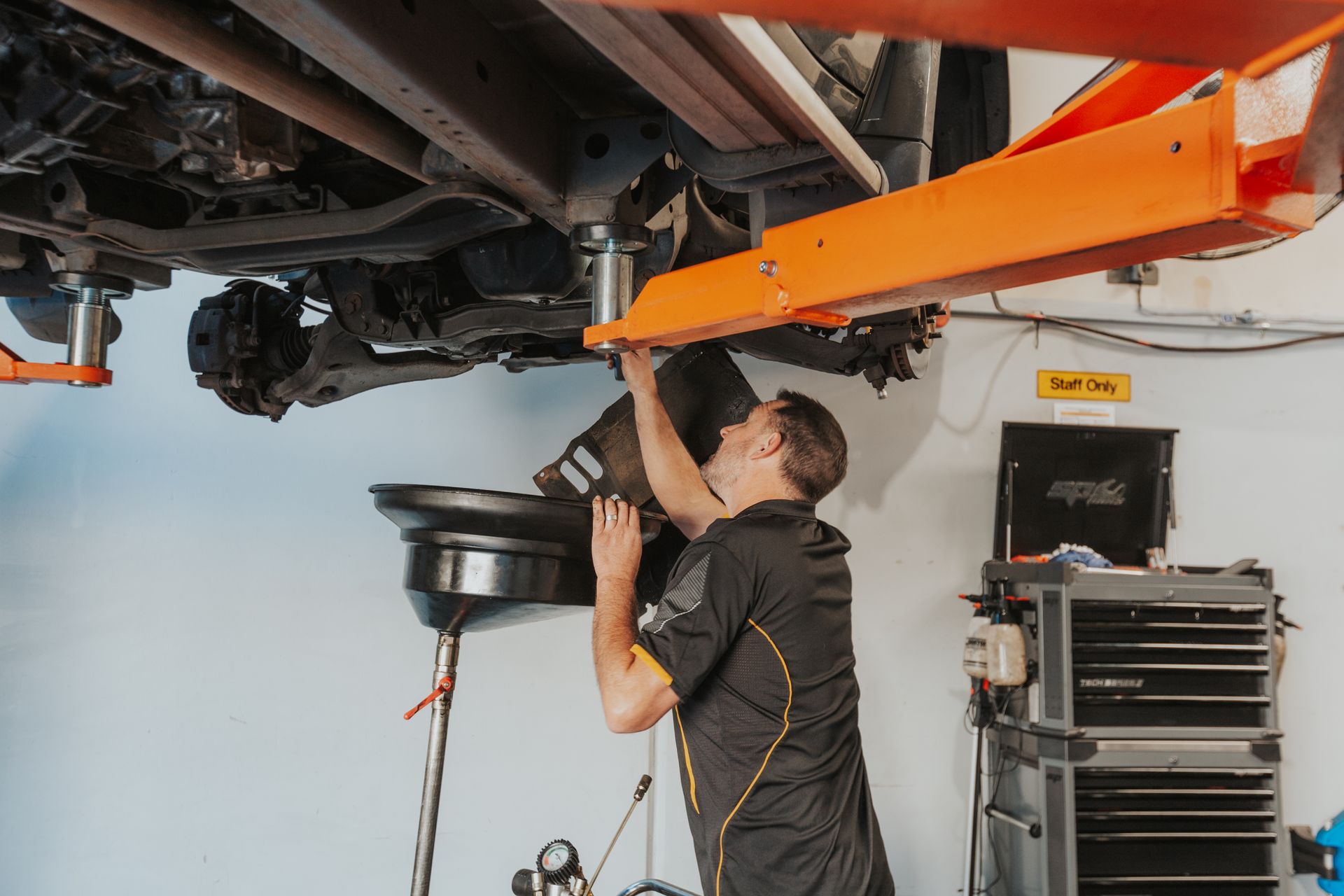 A Man is Working on the Engine of a Car in a Garage — Varsity Lakes Mechanical Repairs In Varsity Lakes, QLD