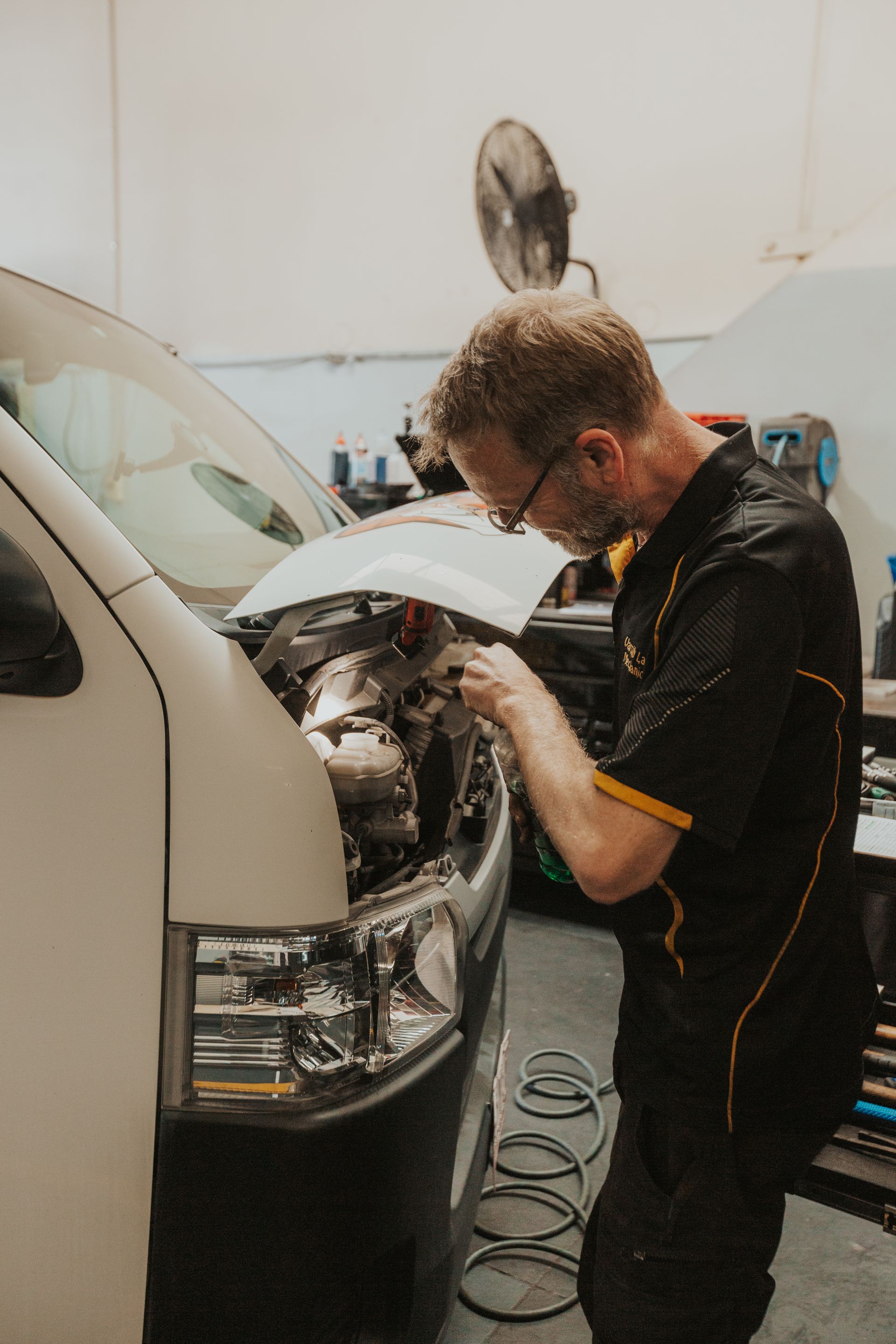 Two men are working under a car in a garage — Varsity Lakes Mechanical Repairs In Varsity Lakes, QLD