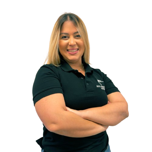 Mulher sorridente vestindo uma camisa polo preta com os braços cruzados contra um fundo branco.