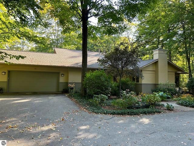 A house with a garage and trees in front of it