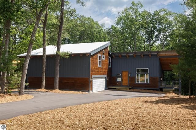 A house with a garage and trees in the background