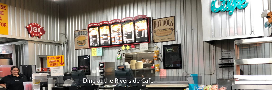 Small retro diner counter with menu boards, soda machines, and a neon sign behind the counter