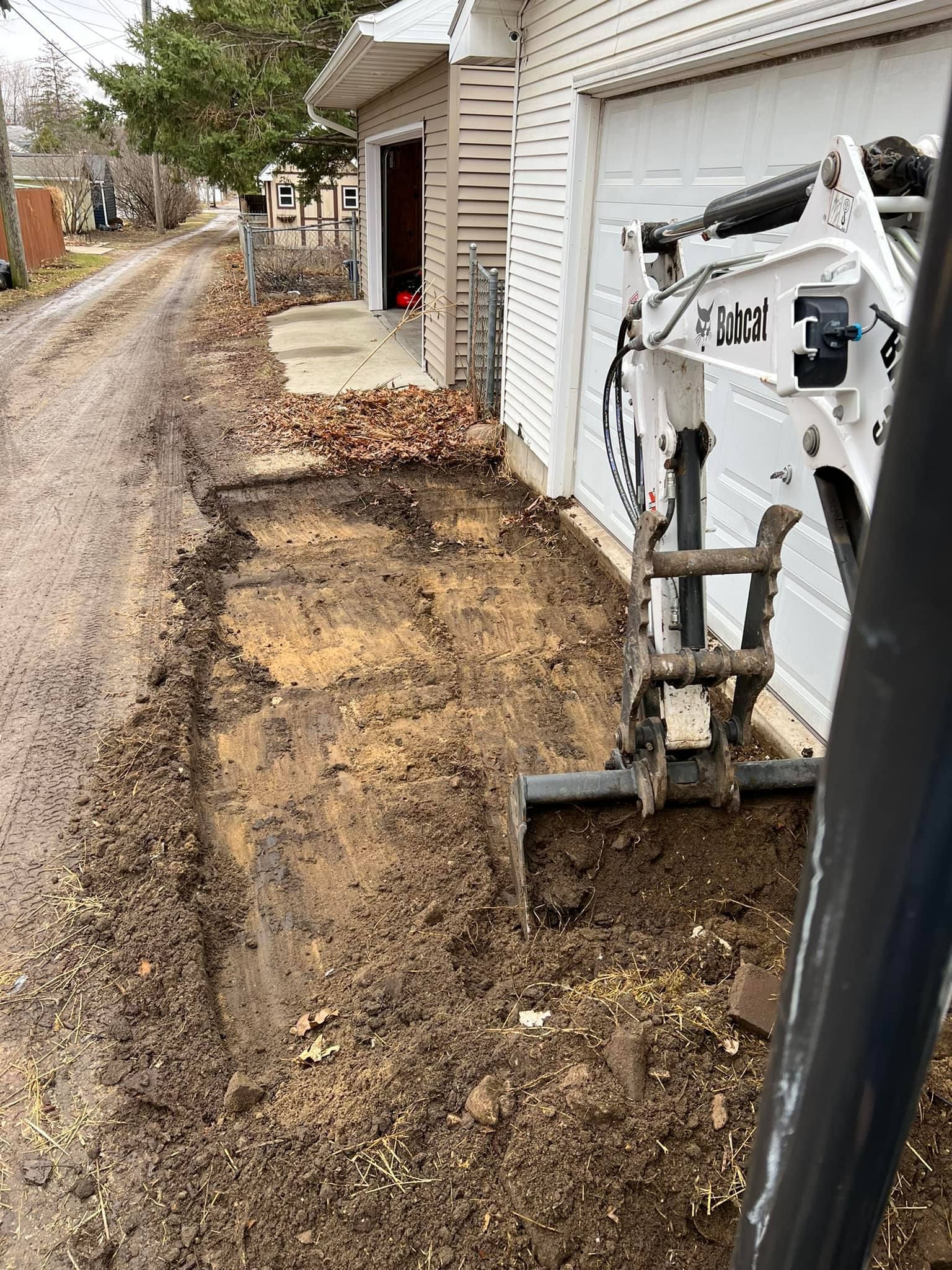 A bulldozer is digging a hole in the ground in front of a house.
