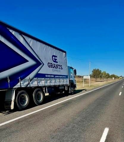 Blue GRANTS Truck Parked on a Rural Roadside Under a Clear Sky — Grants Express in Parkes, NSW