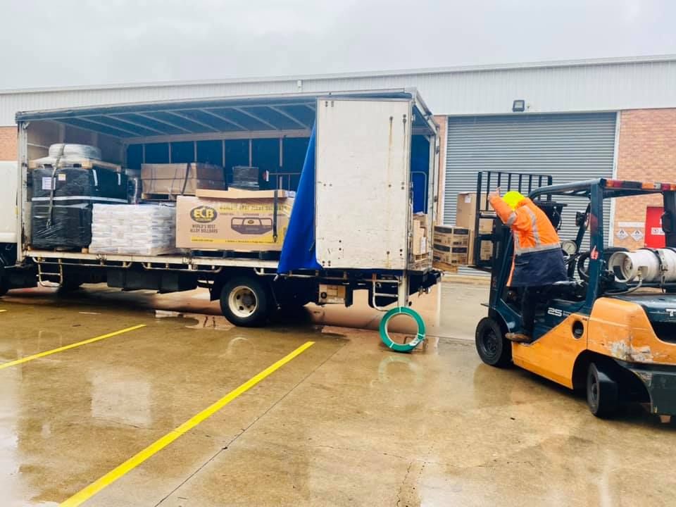 Man is Loading a Truck With a Forklift in a Parking Lot — Grants Express in Lithgow, NSW