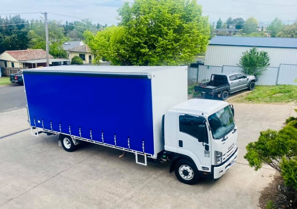 White Truck With a Blue Canopy is Parked on the Side of the Road — Grants Express in Pemulwuy, NSW