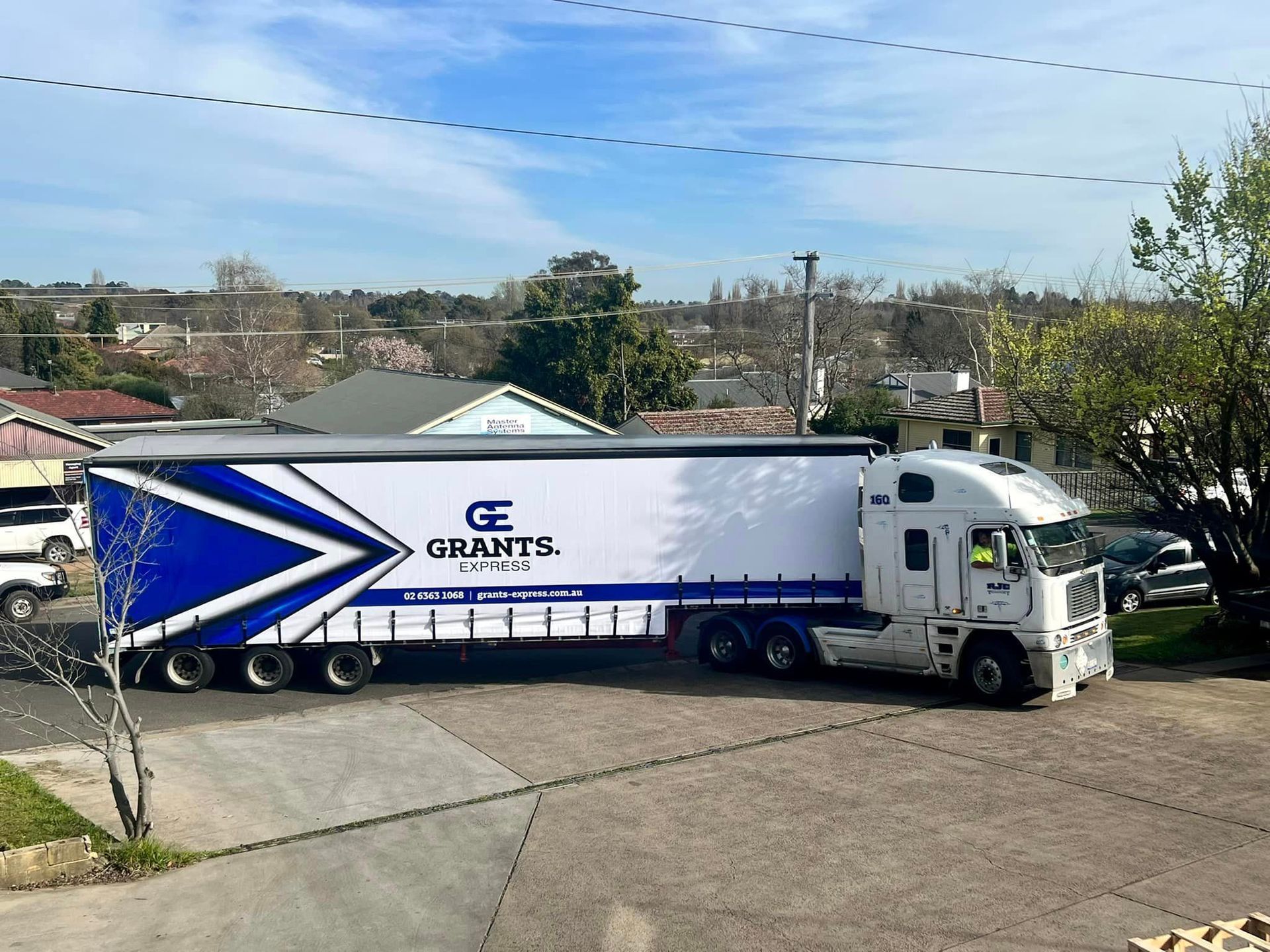 White-and-blue Grants Truck Parked on a Paved Drive Beside a Building, Seen From the Side — Grants Express in Eastern Creek, NSW