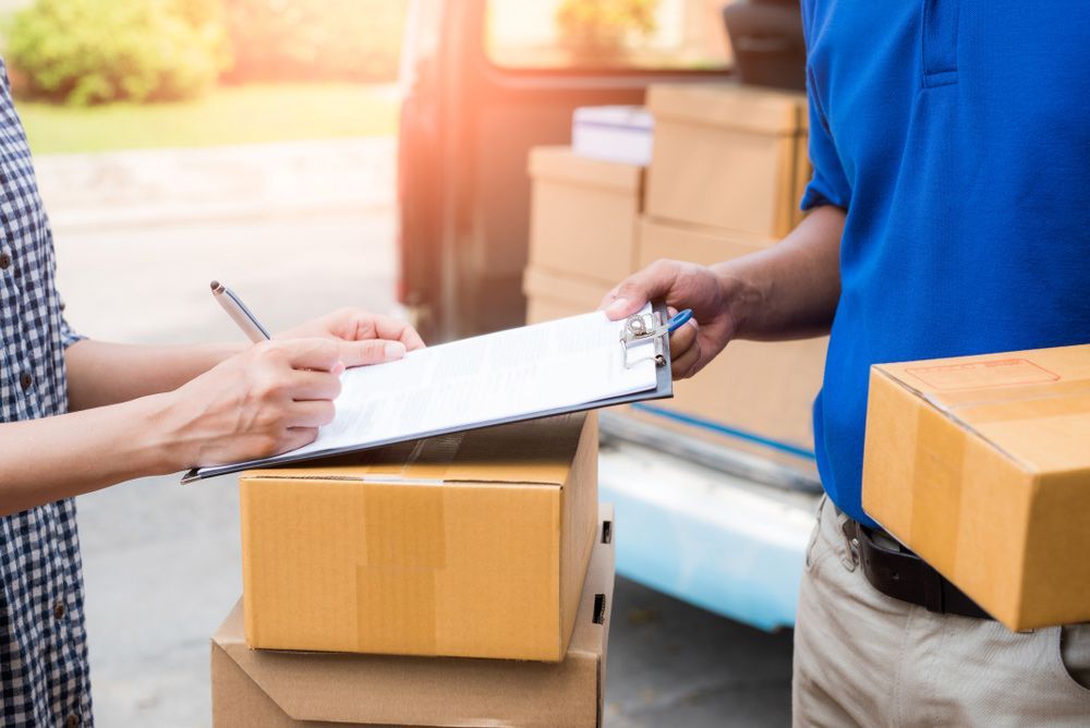 Delivery Man is Handing a Clipboard to a Woman — Grants Express in Smithfield, NSW