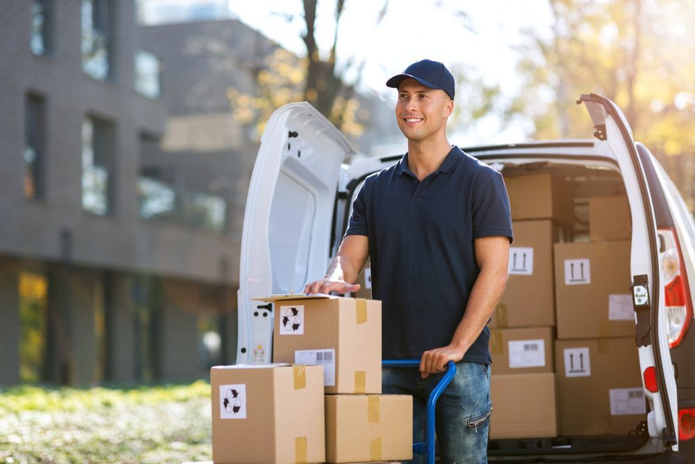 Delivery Man is Standing Next to a Van Filled With Boxes — Grants Express in Bathurst, NSW