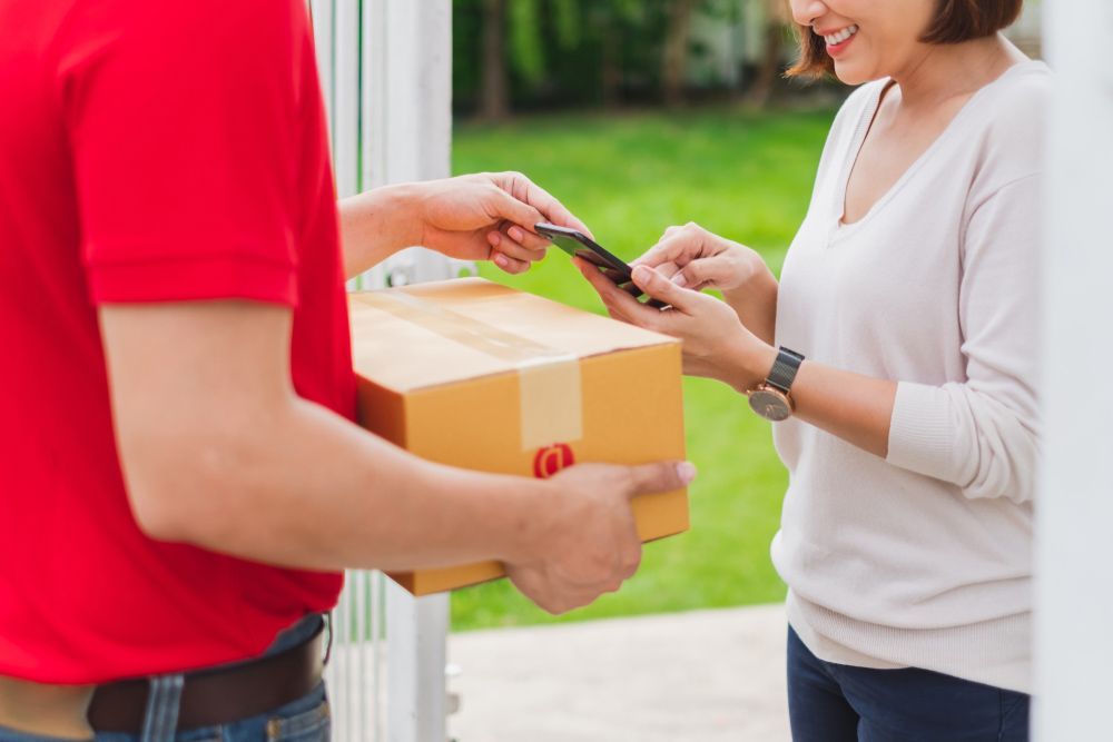 Delivery Man is Handing a Box to a Woman — Grants Express in Pemulwuy, NSW