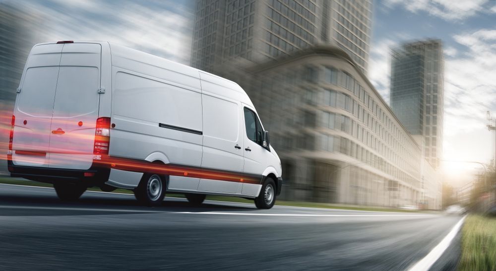 White Van is Driving Down a City Street — Grants Express in Dubbo, NSW