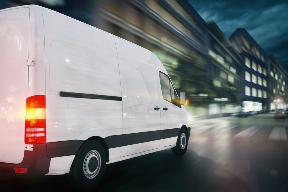 White Van is Driving Down a City Street at Night — Grants Express in Sydney, NSW