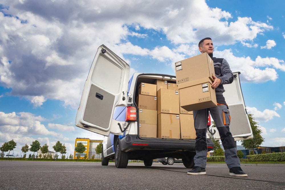 Delivery Man is Standing in Front of a Van Filled With Boxes — Grants Express in Ingleburn, NSW