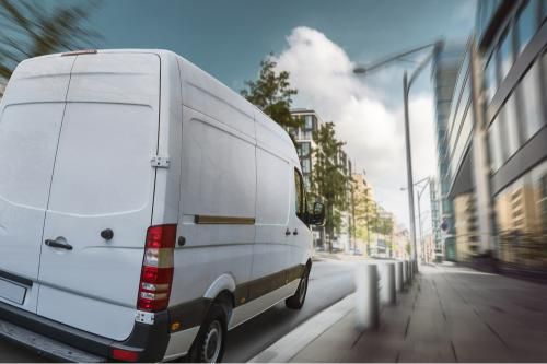 White Van is Driving Down a City Street — Grants Express in Orange, NSW