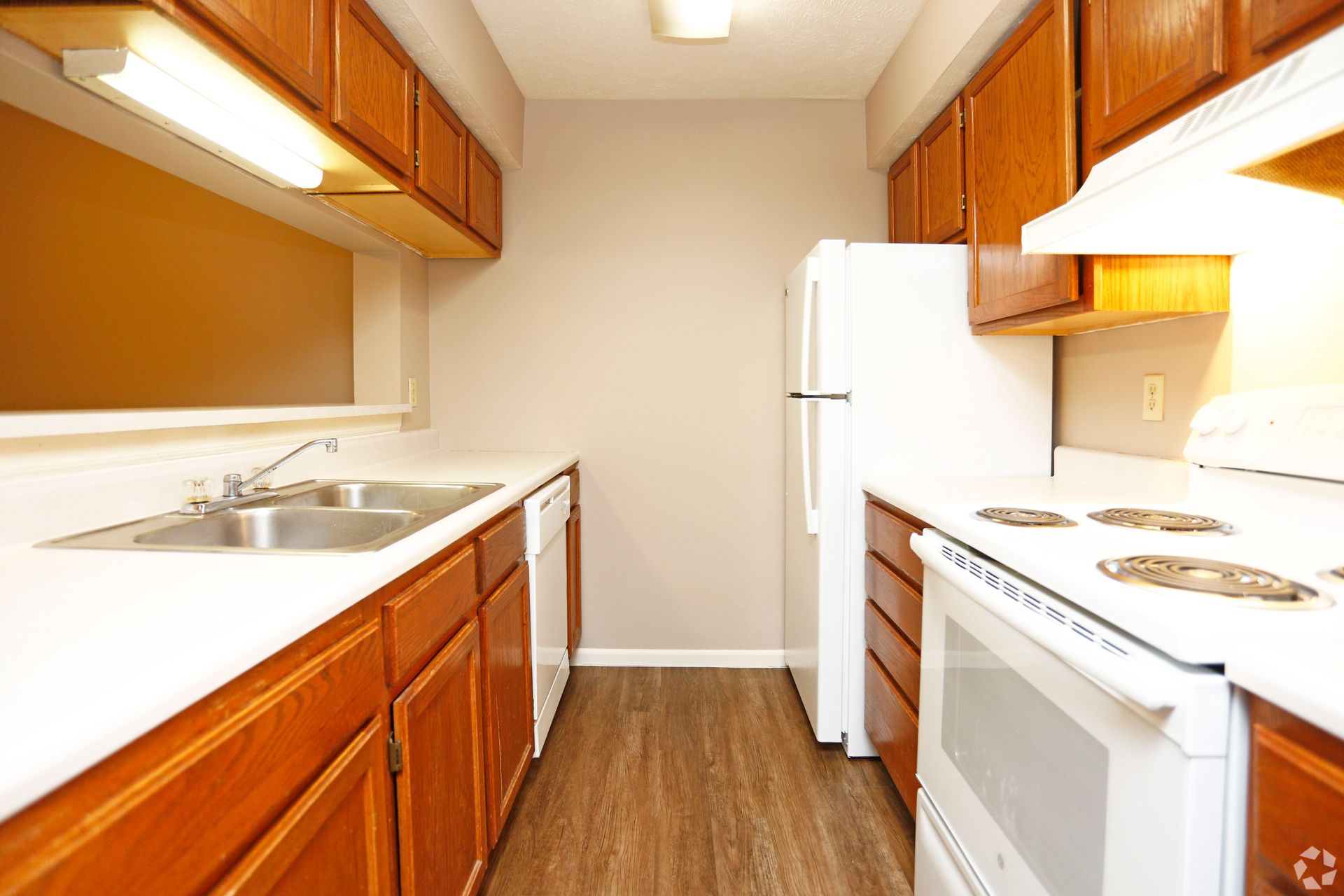 A kitchen with wooden cabinets and white appliances