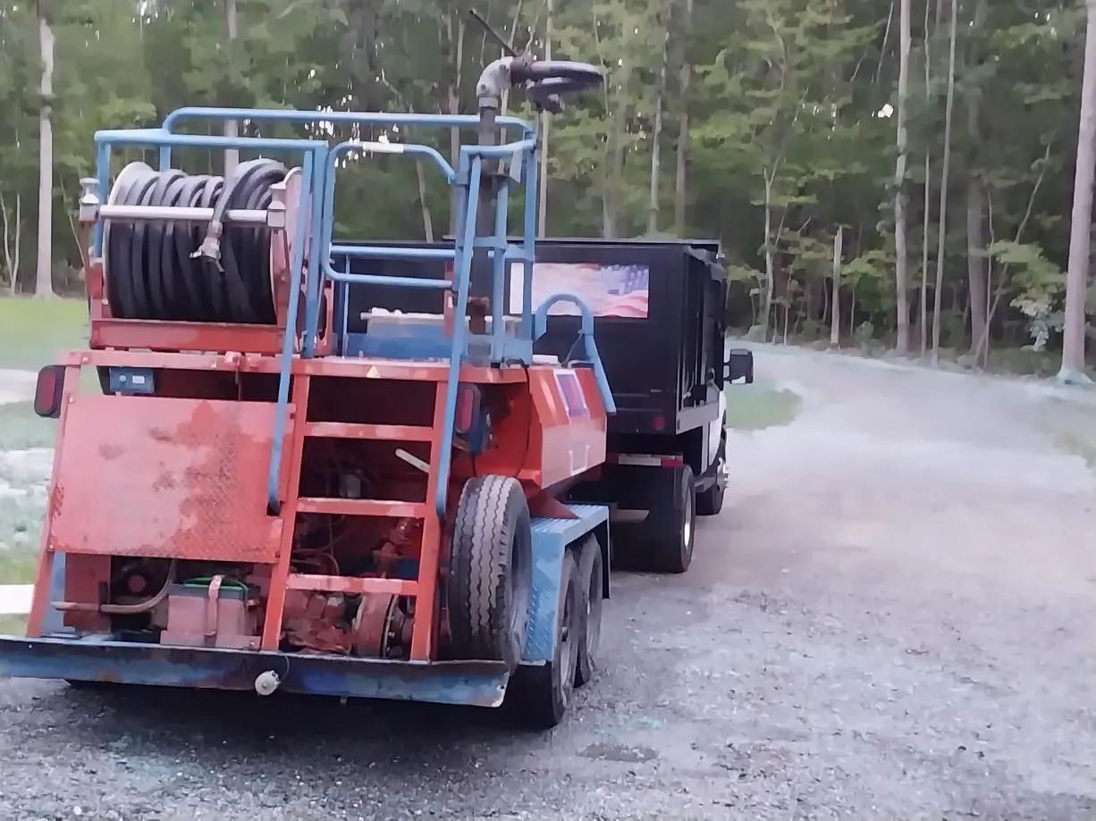 A truck is pulling a trailer with a hose attached to it