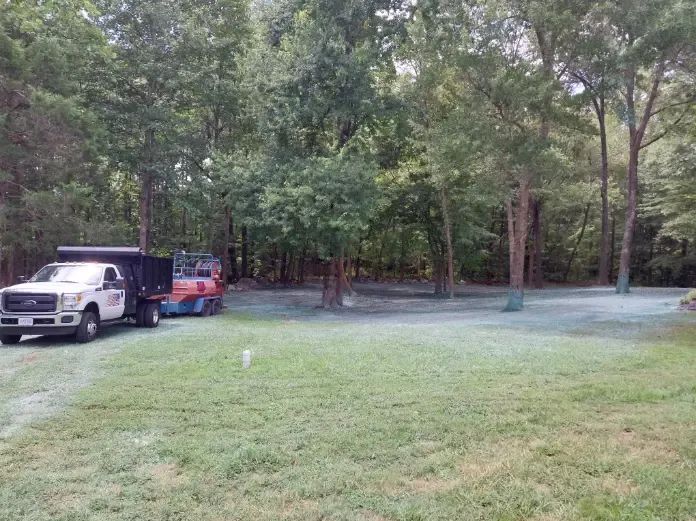 A truck is parked in the middle of a lush green field