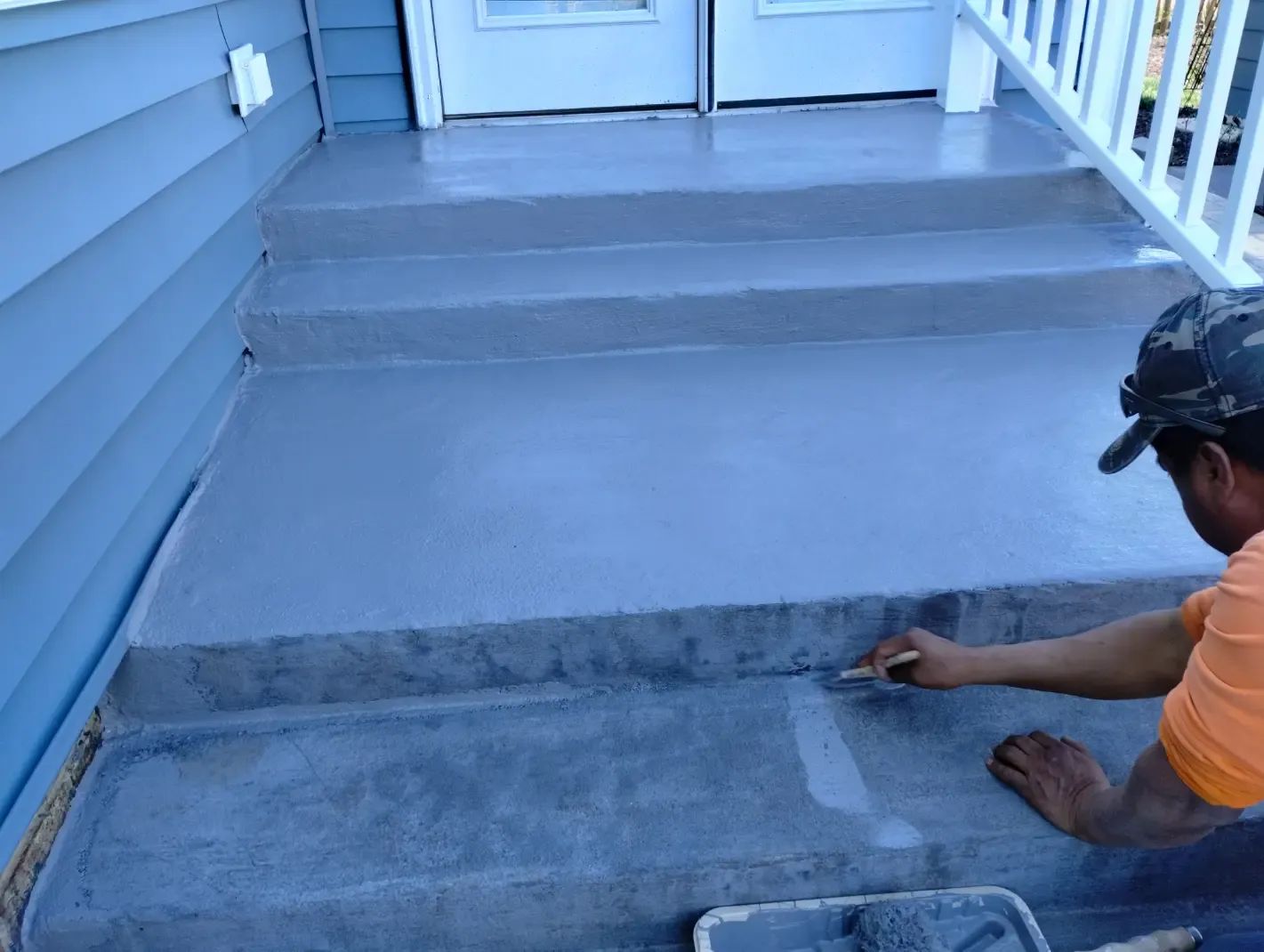 A man is painting the steps of a house