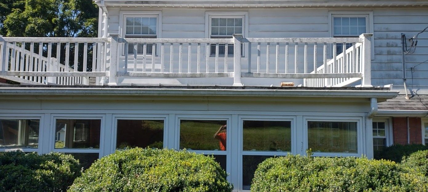 A white house with a balcony and lots of windows