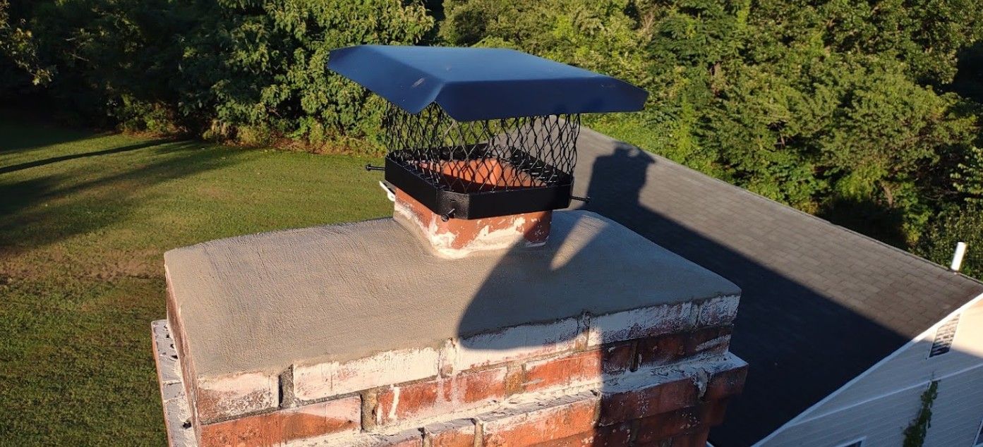 A brick chimney with a blue cover on top of it.